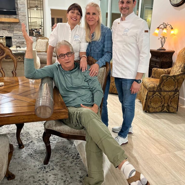 Cuatro personas posan juntas en un salón con muebles elegantes y decoración acogedora.